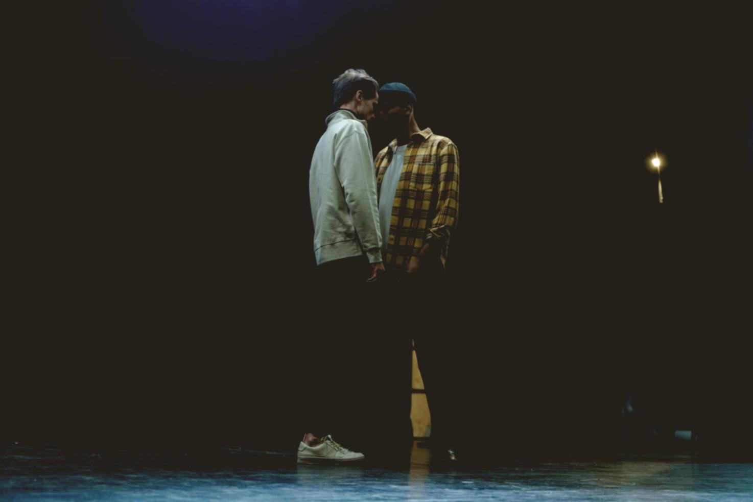 Performers engaged in live improvisation on stage, mid-scene